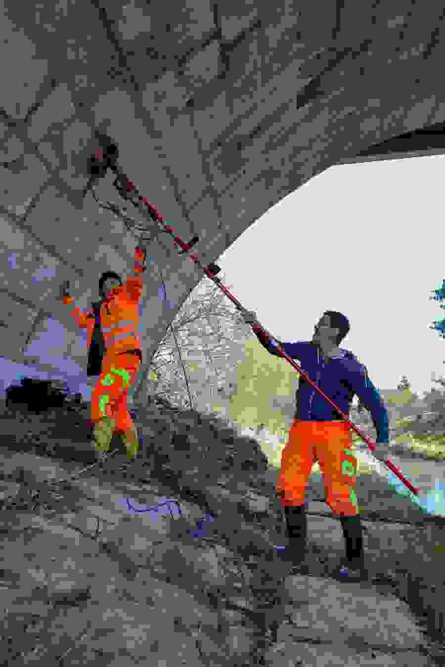 Die Mitarbeitenden der GEOTEST nehmen unterhalb der Brücke ein vertikales Messprofil auf. 