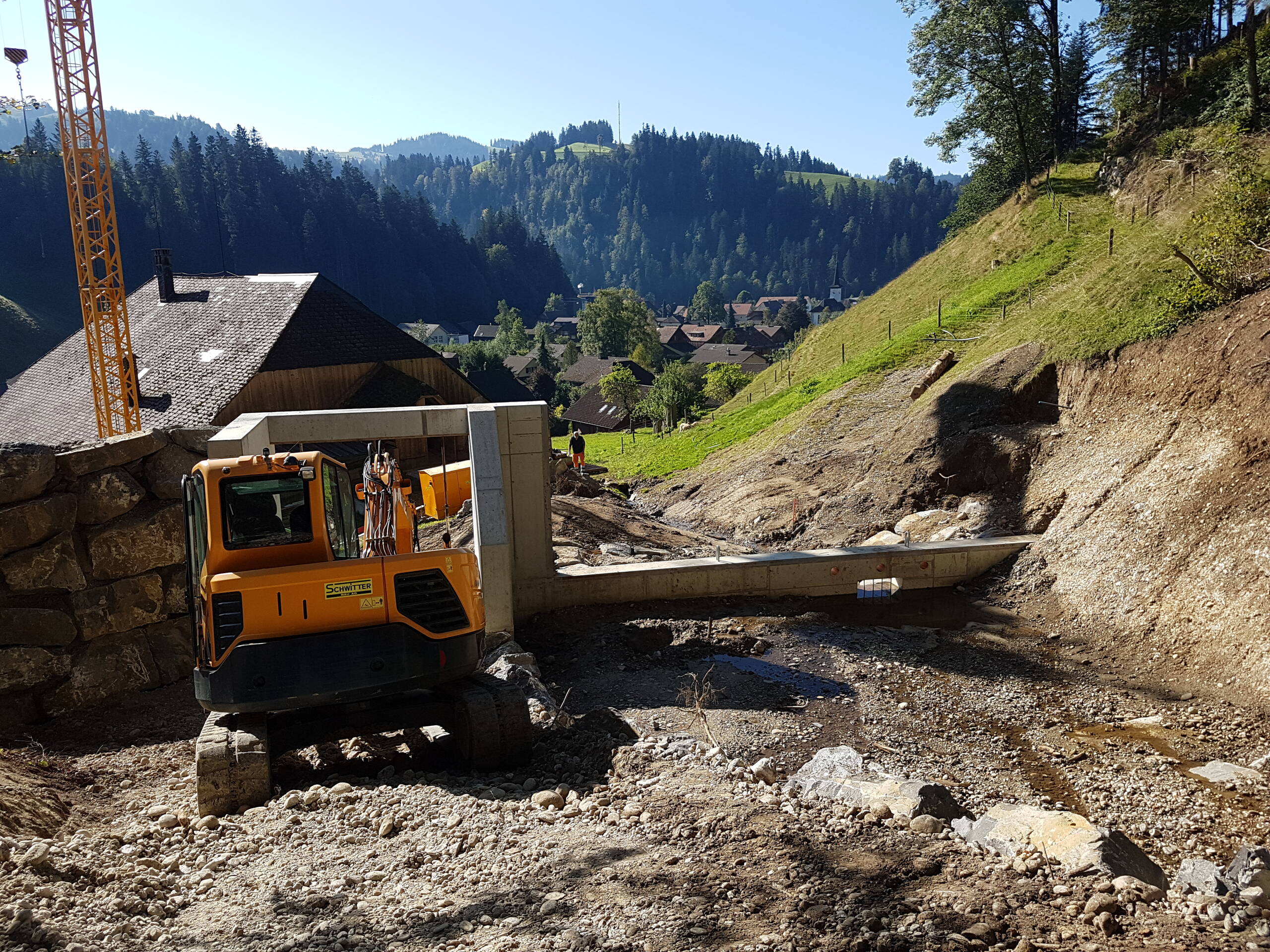 Geotest AG Grâce à la vidange de fond dans les fondations, l’eau peut s’écouler continuellement dans le cours d’eau réaménagé en aval du barrage. Le filet vient se placer au-dessus du socle ; il est ancré latéralement dans la roche et le socle en béton.