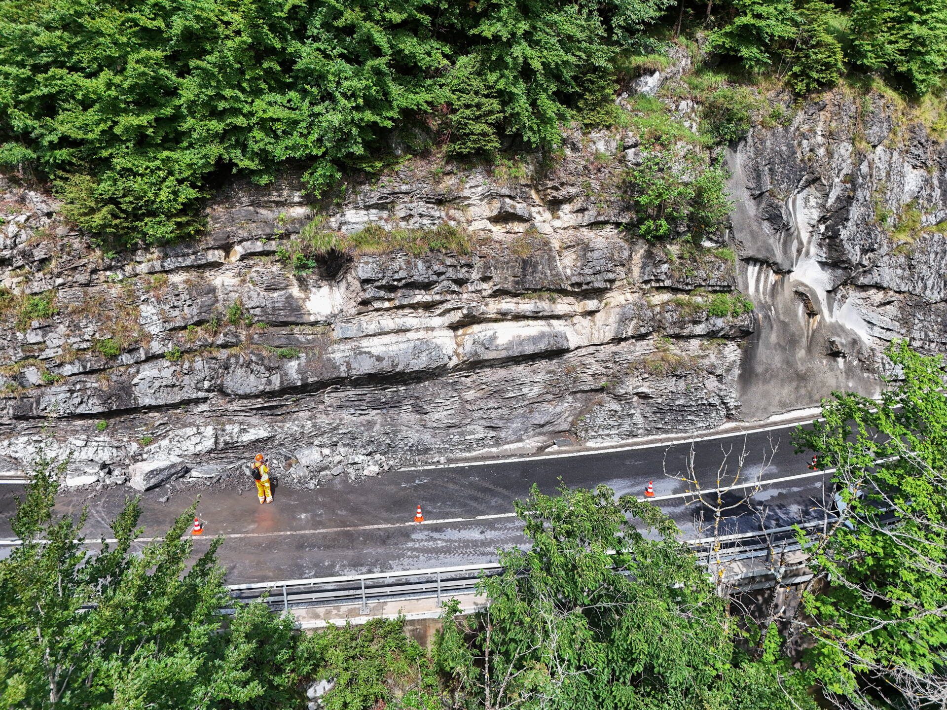 Die Felswand direkt nach dem Ereignis, mit Spezialisten der GEOTEST vor Ort. Im rechten Bereich ist eine Stelle zu sehen, welche bereits früher nach einem Blockschlagereignis gesichert worden war. Die Felswand direkt nach dem Ereignis, mit Spezialisten der GEOTEST vor Ort. Im rechten Bereich ist eine Stelle zu sehen, welche bereits früher nach einem Blockschlagereignis gesichert worden war.