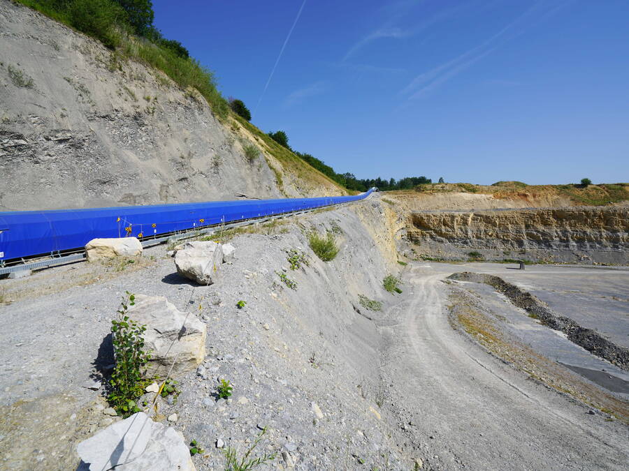 Die Zulieferung des Auffüllmaterials erfolgt über den bestehenden Bahnanschluss und wird von der Abladestelle über Förderbänder in den Steinbruch transportiert.