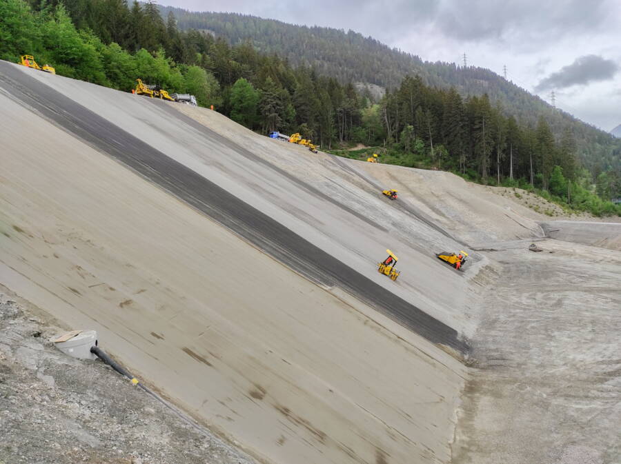 Einbau und Abwalzen Flächenfilter, im Vordergrund die eingebaute erste Schicht der geologischen Ersatzbarriere.