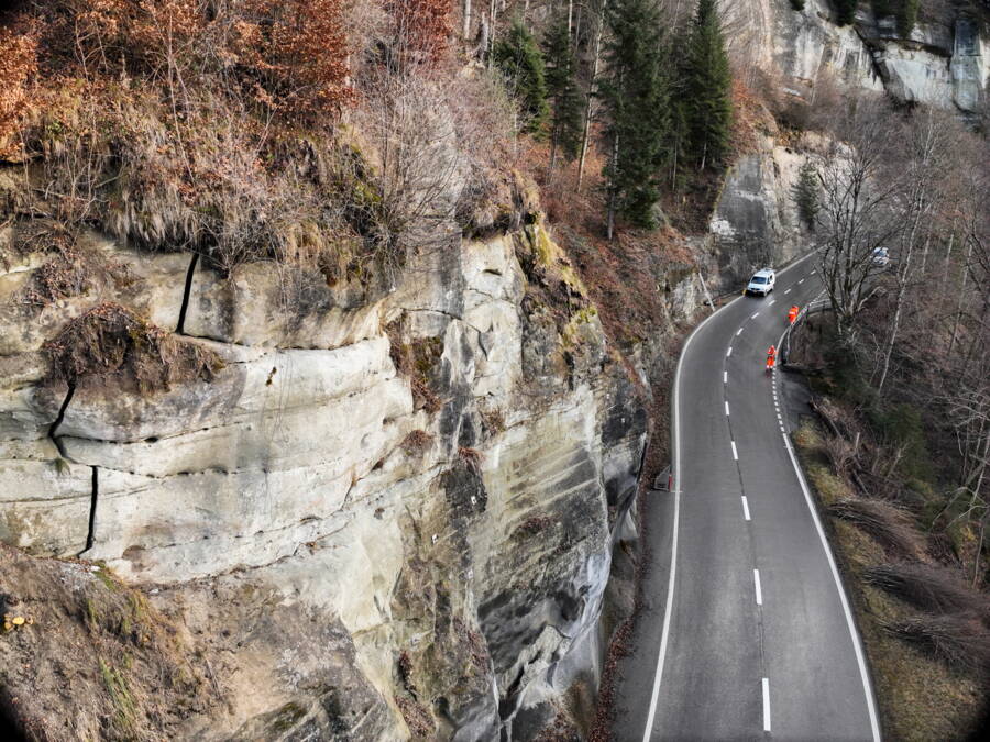 Les images de la paroi prises par drone au-dessus de la route montraient des fissures dans la roche. Les images de la paroi prises par drone au-dessus de la route montraient des fissures dans la roche.