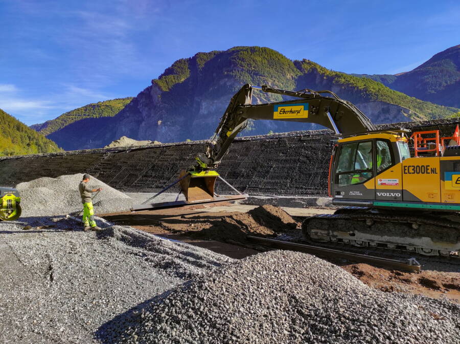 Präziser Schichtauftrag von Trisoplast vor dem Verdichten. Um ein Austrocknen oder Aufquellen zu verhindern, wird die Schicht unmittelbar mit Filtermaterial abgedeckt und beschwert.