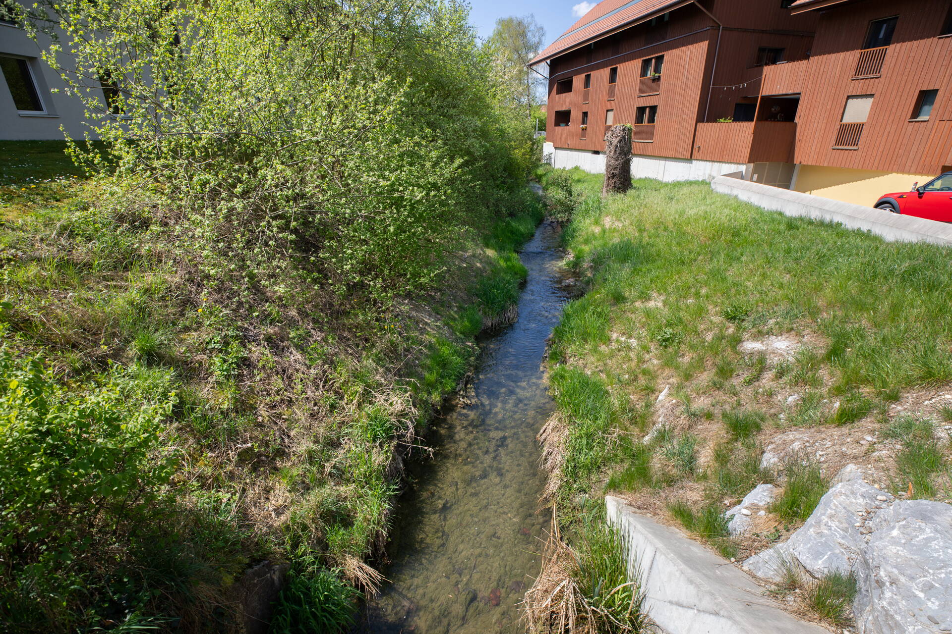 Sur cette photo, l’espace réservé au cours d’eau ainsi que la paroi de protection contre les crues, qui est partiellement intégrée au bâtiment, sont clairement visibles. Cette solution permet d’aménager une berge plus douce et d’offrir davantage d’espace à la nature. 