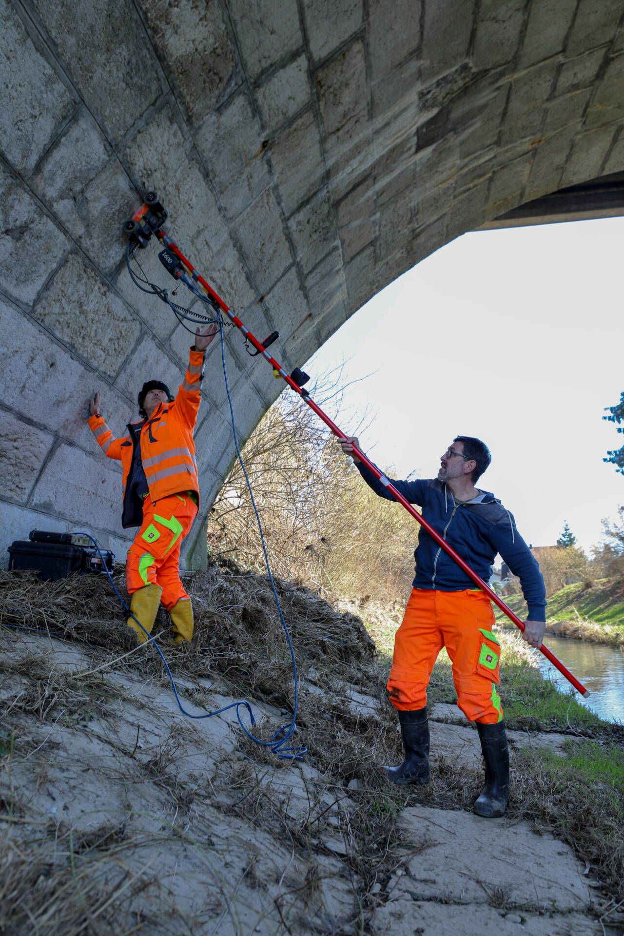 Die Mitarbeitenden der GEOTEST nehmen unterhalb der Brücke ein vertikales Messprofil auf.  Die Mitarbeitenden der GEOTEST nehmen unterhalb der Brücke ein vertikales Messprofil auf.