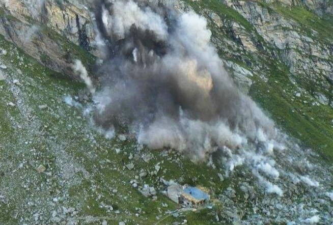 Falling rock masses during the safety blasting (Photo: T. Meier).