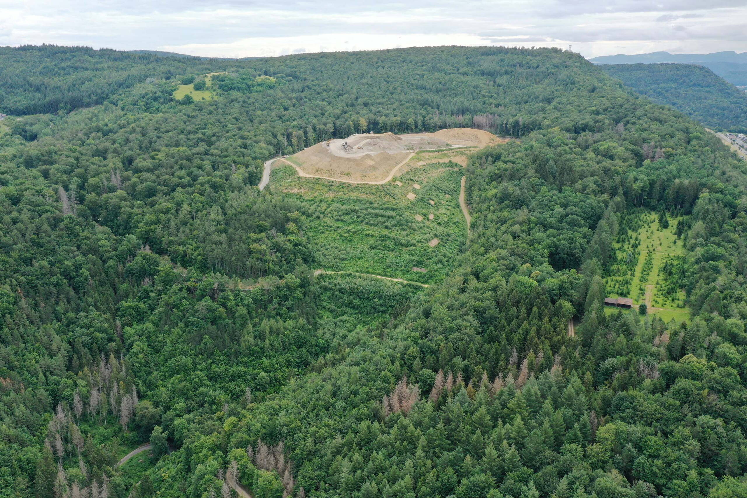 Flugaufnahme der aktiven Deponie Höli und der ehemaligen, renaturierten Deponie Lindenstock links im Hintergrund. Flugaufnahme der aktiven Deponie Höli und der ehemaligen, renaturierten Deponie Lindenstock links im Hintergrund.