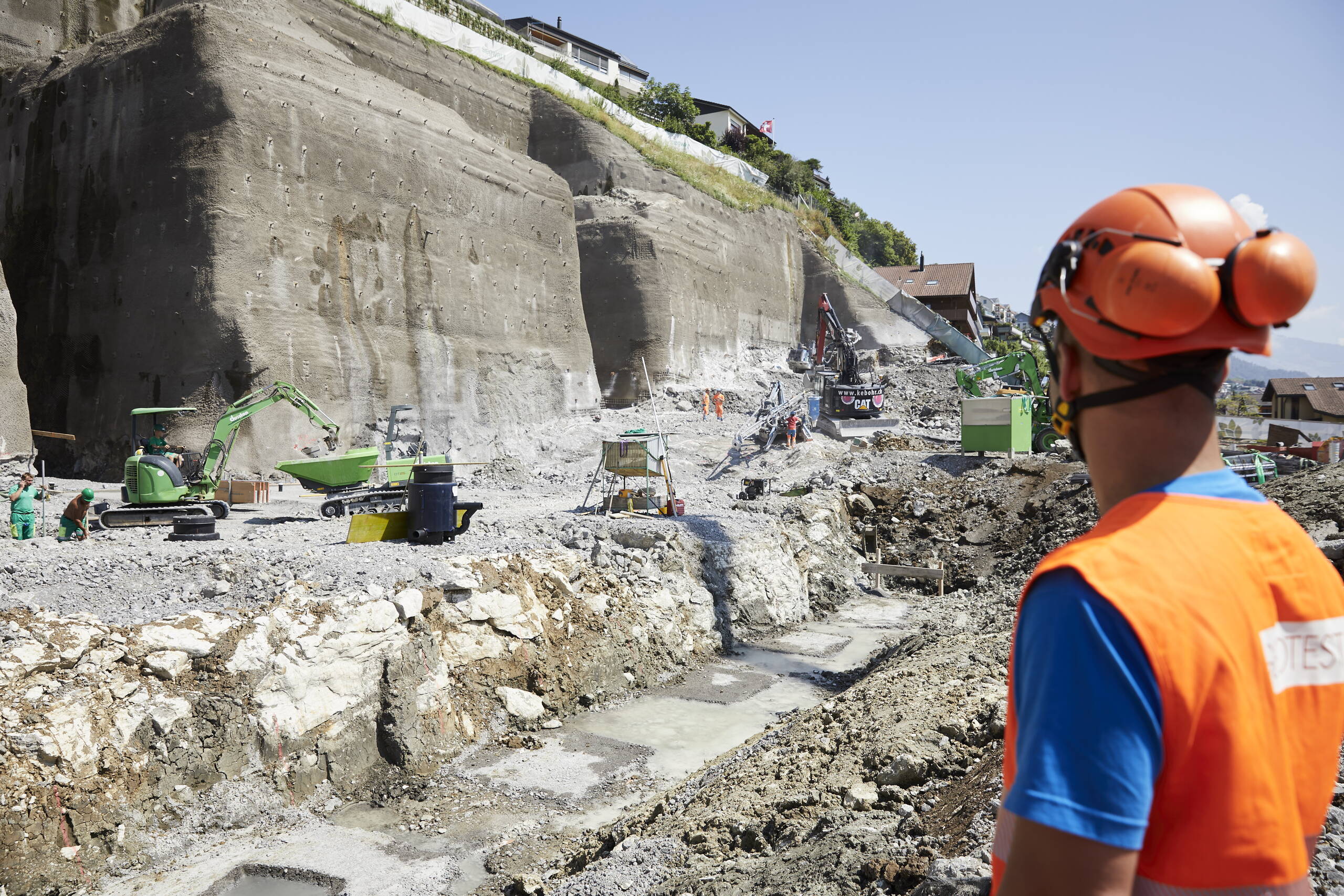 While rock removal by detonation is continuing (background), the floor is already being concreted (foreground). While rock removal by detonation is continuing (background), the floor is already being concreted (foreground).